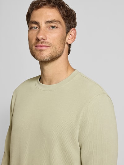 Männermodel trägt Regular Fit Langarmshirt aus Baumwoll-Mix Modell 'We_Tempest' von BOSS Orange in Beige, strukturierte Oberfläche, Nahaufnahme Oberkörper.