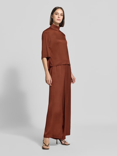 Vrouwenmodel draagt Wide Fit broek met elastische band Model 'Tweezer' van DRYKORN in acetaatmix, roestbruin, wide fit, gladde stof, damesbroek, binnenbeenlengte maat 27/34 80 cm, bandwijdte 37 cm, voorkant volledige lichaamsweergave.