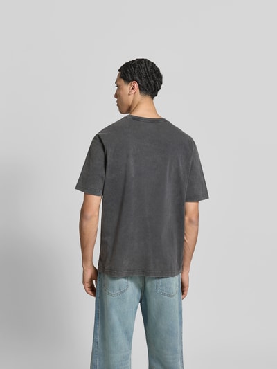 Männermodel trägt Relaxed Fit T-Shirt mit Logo-Print von MAISON KITSUNÉ aus reiner Baumwolle, dunkelgrau, Rückansicht, Ganzkörperansicht Rückansicht.
