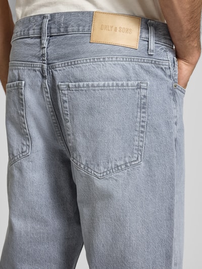 Männermodel trägt Straight Fit Jeans aus reiner Baumwolle Modell 'EDGE' von Only & Sons in Hellblau, Detailaufnahme Rückansicht, Denimstruktur, Label-Prägung sichtbar, 5-Pocket-Design, Stitching-Details.