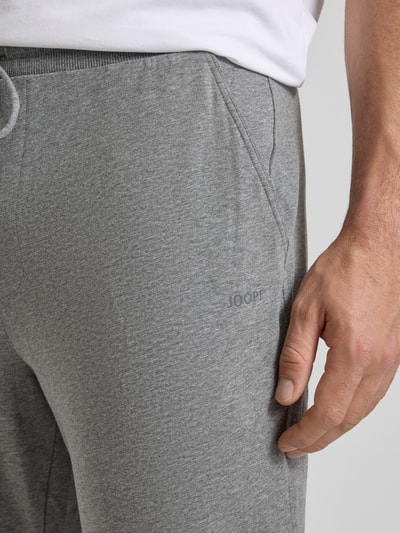 Männermodel trägt Sweatpants mit elastischem Bund und Tunnelzug von JOOP! Collection, Baumwoll-Mix mit Stretch-Anteil, Nahaufnahme Oberschenkel.