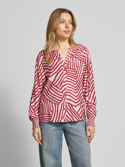Vrouwenmodel draagt Hemdbluse met knoopsluiting Modell 'BECCA' van Soyaconcept, los model, viscosemix, V-hals, rode en witte abstracte strepen, voorkant, busteshot.