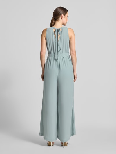 Frauenmodel trägt Jumpsuit mit rückseitigem V-Ausschnitt von Zero in Hellblau, taillierter Schnitt, Bindegürtel, fließender Stoff, Ganzkörperansicht Rückansicht.