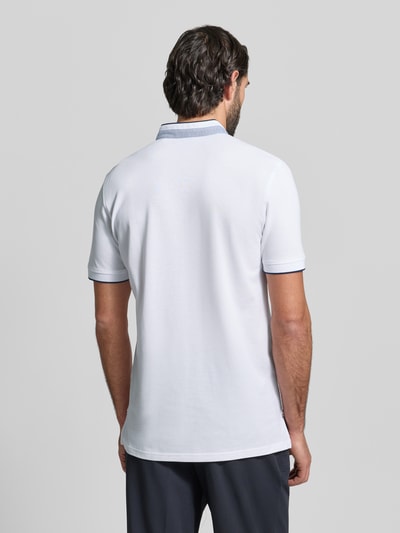 Männermodel trägt Regular Fit Poloshirt aus reiner Baumwolle mit Stehkragen von Christian Berg Men, weiß, krój regular fit, stójka z listwą guzikową, krótki rękaw, elastyczne zakończenia rękawów, długość tyłu w rozmiarze M: 75 cm, ganzkörperansicht rückansicht.