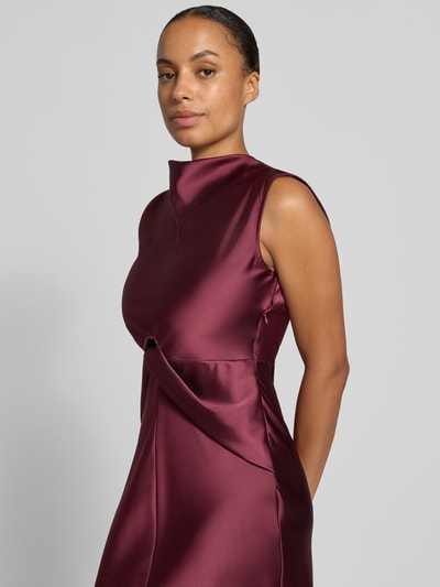 Frauenmodel trägt Cocktailkleid aus Satin mit Raffungen von Rinascimento in dunklem Bordeaux, glänzende glatte Textur, Nahaufnahme Oberkörper.