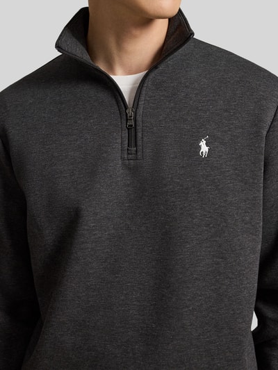 Männermodel trägt Relaxed Fit Troyer aus Baumwoll-Mix von Polo Ralph Lauren, dunkelgrau, Reißverschluss, weiche Textur, Nahaufnahme Oberkörper.