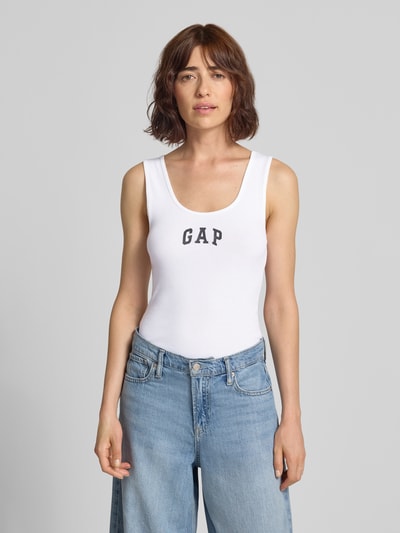 Frauenmodel trägt Tanktop mit Logo-Print und Rundhalsausschnitt von GAP in Weiß, körpernah geschnitten, Baumwoll-Mix, Feinripp, Ganzkörperansicht von vorne.