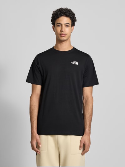 Männermodel trägt Regular Fit T-Shirt aus Baumwoll-Mix Modell 'VERTICAL' von The North Face mit Label-Print, Schwarz, Ganzkörperansicht von vorne. Herren T-Shirt, Rundhalsausschnitt, Rückenlänge bei Größe M 71 cm.