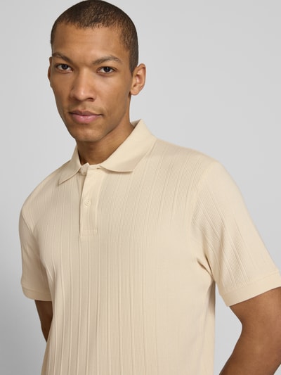 Männermodel trägt Regular Fit Poloshirt reiner Baumwolle Modell 'COLE' von SELECTED HOMME, beige, strukturierte Optik, Nahaufnahme Oberkörper.