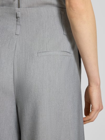 Frauenmodel trägt Stoffhose mit französischen Eingrifftaschen Modell 'Hanna' von My Essential Wardrobe, hellgrauer Material-Mix mit Viskose-Anteil, angedeutete Gesäßleistentasche, High Wide Fit, Haken- und Reißverschluss, Detailaufnahme Rückansicht. Bundweite bei Größe 36: 38 cm, Innenbeinlänge 79 cm.