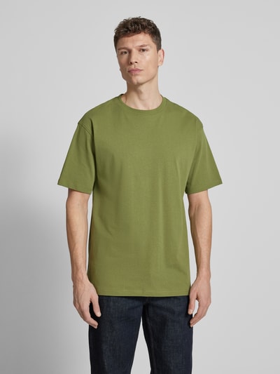 Męski model nosi Relaxed Fit T-Shirt aus Bio-Baumwoll-Mix Modell 'MAARKOS' von Armedangels, jednokolorowy, wyhaftowane logo, okrągły dekolt, krótki rękaw, dżersej, mieszanka bawełny ekologicznej; Ganzkörperansicht von vorne.