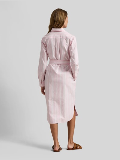 Frauenmodel trägt Regular Fit Oxford-Hemdblusenkleid mit Gürtel von Polo Ralph Lauren mit Allover-Streifenmuster in Pastell, Midi-Länge, Ganzkörperansicht Rückansicht.