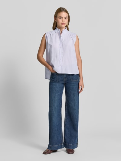 Frauenmodel trägt Blusentop aus Baumwolle mit Stehkragen von Emily Van den Bergh, hellblau mit feinen Streifen, Regular Fit, Knopfleiste, kombiniert mit Jeans; Ganzkörperansicht von vorne.