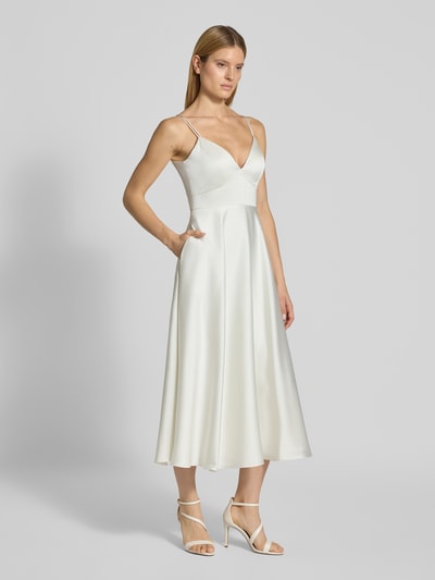 Frauenmodel trägt Brautkleid aus Satin mit V-Ausschnitt von Jake*s Cocktail, A-Linie, Midikleid, Spaghettiträger, rückseitiger Reißverschluss, cremefarben, glatte Textur, Ganzkörperansicht von vorne.