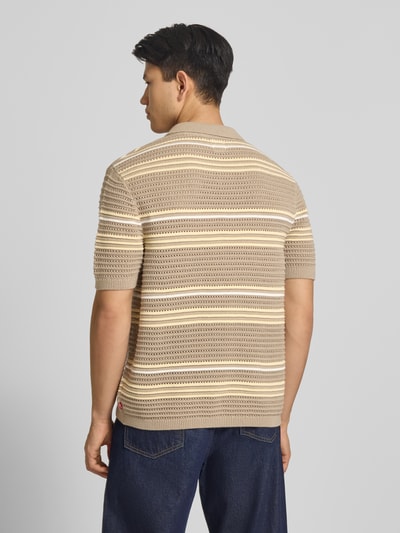 Männermodel trägt Relaxed Fit Poloshirt aus reiner Baumwolle Modell 'LAGUNA' von Levi's®, Strickoptik, gestreift, Ganzkörperansicht Rückansicht.