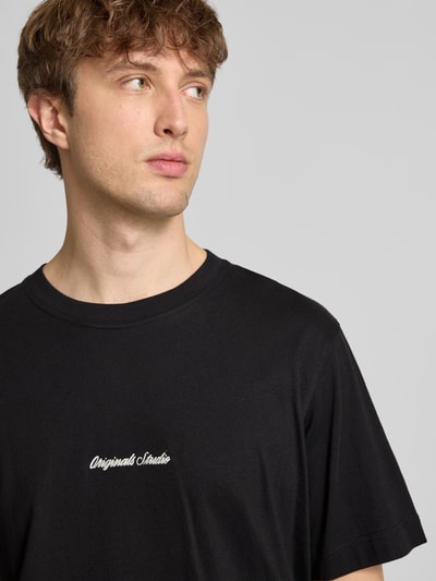 Männermodel trägt T-Shirt mit Label-Stitching Modell 'NORREBRO' von Jack & Jones, schwarze Baumwolle, Nahaufnahme Oberkörper.