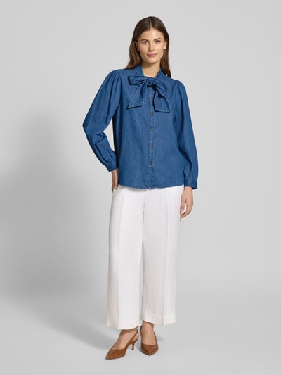 Frauenmodel trägt Regular Fit Schluppenbluse im Denim-Look Modell 'KAIRON' von B.Young aus reiner Baumwolle, Knopfleiste, weiße Hose, Ganzkörperansicht von vorne.