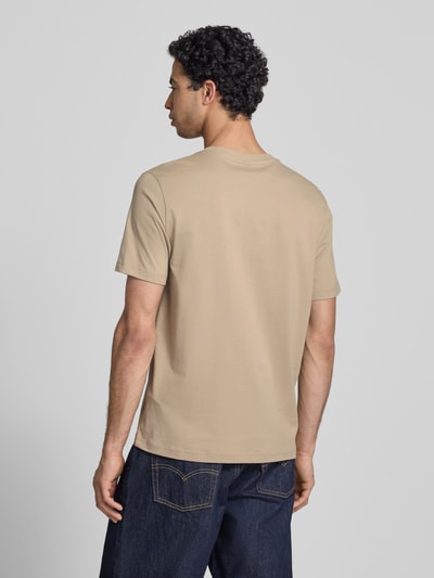 Männermodel trägt T-Shirt mit Logo-Stitchings Modell 'ICONS CONTRAST' von CHAMPION in Beige, Baumwoll-Mix, Ganzkörperansicht Rückansicht