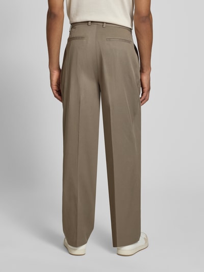 Męski model nosi Hose mit Bügelfalten Modell 'Reece' od Les Deux, lyocell-bawełna, krój regular fit, kolor beżowy, zdjęcie całej sylwetki od tyłu. Szerokość w rozmiarze 32/32: 46 cm, długość wewnętrzna nogawki: 80 cm.