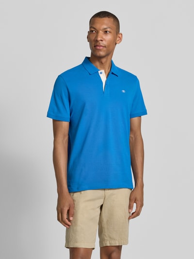 Männermodel trägt Regular Fit Poloshirt aus reiner Baumwolle von Tom Tailor in Blau, glatte Textur, Ganzkörperansicht von vorne, Herren.