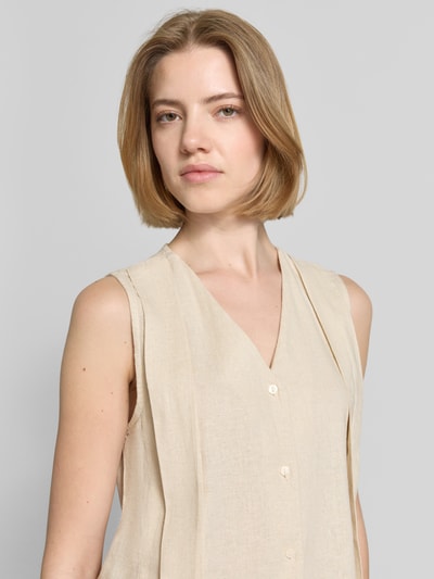 Frauenmodel trägt Weste aus Leinen-Viskose-Mix Modell 'LINNO' von ICHI in Beige mit V-Ausschnitt und Knopfleiste, Nahaufnahme Oberkörper. Regular Fit, sichtbare glatte Struktur, neutrale Farbe; Maße für Größe 36: Rückenlänge 53 cm, Schulterbreite 34 cm, Brustweite 47 cm.