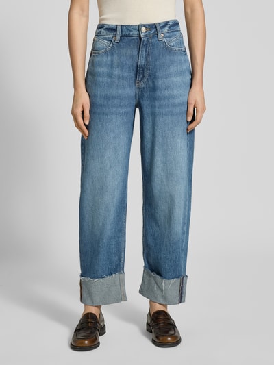 Frauenmodel trägt Relaxed Fit Jeans aus reiner Baumwolle Modell 'C_BALLOON HR FUP' von BOSS Orange in blauer Denim-Optik mit Kontrastnähten, 5-Pocket-Design, High-Waist, Label-Patch, Nieten und fixiertem Umschlag, Ganzkörperansicht von vorne.