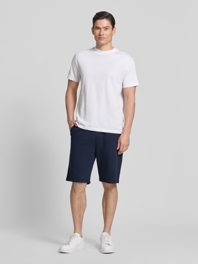 Męski model nosi Relaxed Fit Bermudas aus Baumwoll-Mix Modell 'DETROIT' od s.Oliver RED LABEL, granatowy, gładki, wafel, przód, cała sylwetka