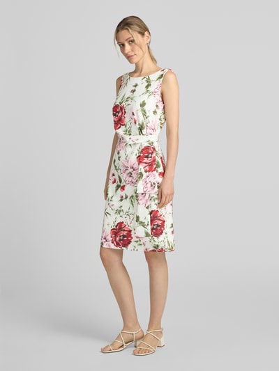 Vrouwenmodel draagt tailliertes cocktailjurk met all-over bloemenmotief van Vera Mont in wit met rode en roze accenten, full body voorkant.