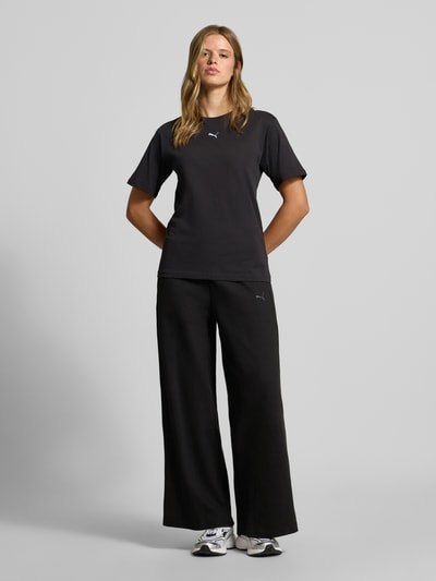 Frauenmodel trägt Relaxed Fit Sweathose aus reiner Baumwolle von PUMA, schwarze Farbe, weite Form, strukturierte Textur, Ganzkörperansicht von vorne, Damen Sweathose von PUMA.