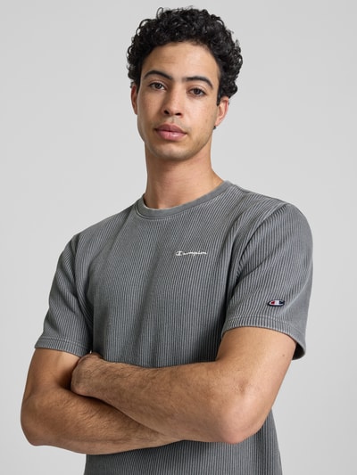 Männermodel trägt T-Shirt mit Strukturmuster und Label-Stitchings von CHAMPION, grau, Baumwoll-Mix, Regular-Fit, Nahaufnahme Oberkörper.