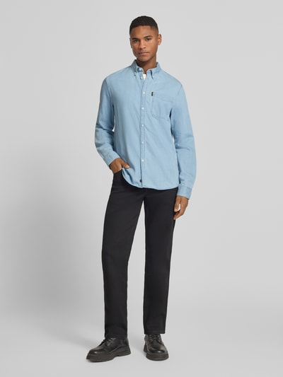 Männermodel trägt Regular Fit Freizeithemd mit Brusttasche und Label-Detail von PME Legend in Hellblau, schwarze Hose, Ganzkörperansicht von vorne. Baumwolle, Button-Down-Kragen, Knopfleiste, Sportmanschetten.