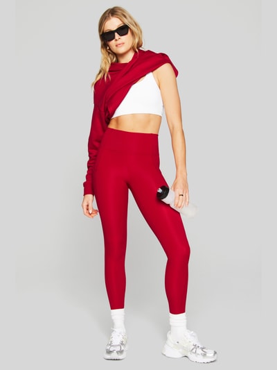 Frauenmodel trägt Slim Fit Leggins mit Beintaschen Modell 'OASIS' von Fabletics, elastischer Material-Mix, Ganzkörperansicht von vorne.