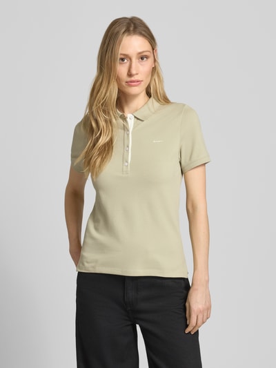 Frauenmodel trägt Slim Fit Poloshirt mit Label-Stitching von Gant aus Baumwoll-Elasthan-Mix, Knopfleiste, Rückenlänge 59 cm, Ganzkörperansicht von vorne.