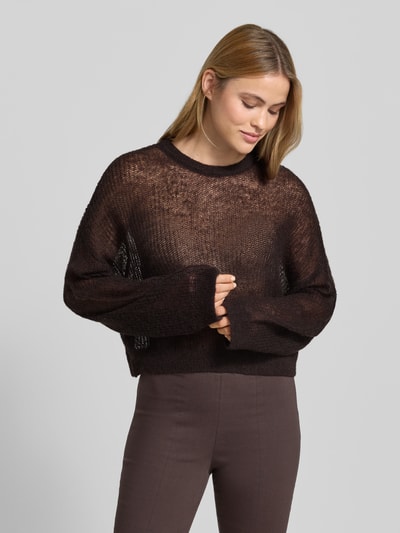 Frauenmodel trägt sommerlicher cropped Strickpullover - curated by Mary Braun von Style Icon Collection in Braun, Strick-Optik, Relaxed-Fit, Rundhalsausschnitt, elastische Abschlüsse, Rückenlänge bei Größe S 53 cm, Ärmellänge 72 cm, Ganzkörperansicht von vorne.