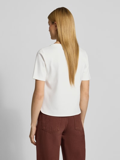 Frauenmodel trägt T-Shirt mit Brusttasche und Motiv von More & More in Weiß, Regular-Fit, Viskose-Mix mit Stretch-Anteil, Rückansicht, Rückenlänge 54 cm bei Größe 36.