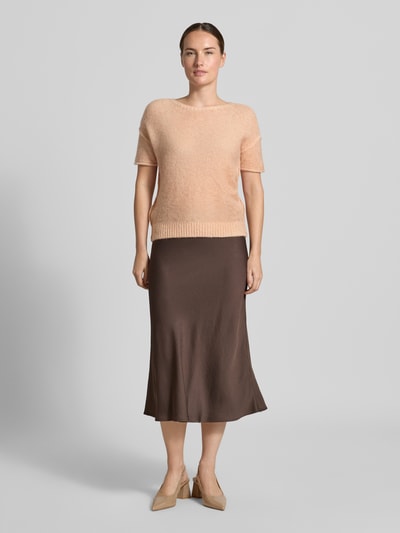 Frauenmodel trägt Strickpullover mit Alpaka-Anteil von Luisa Cerano, gerader Schnitt, Rundhalsausschnitt, zarte Nude-Farbe, Ziernähte, gerippter Bund, Kombi mit leicht glänzendem braunem Rock, sanfte Textur, Ganzkörperansicht von vorne.