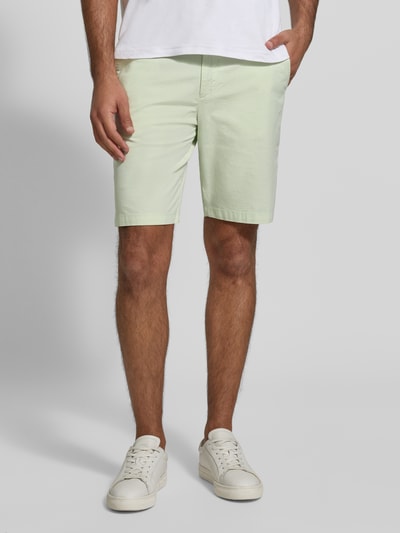 Mężczyzna nosi Tapered Chinoshorts aus Baumwoll-Mix Modell 'CHINO_TAPERED_DS_3S' od BOSS Orange, jasny odcień, prosty krój, bawełniany materiał, widok z przodu na całe ciało.
