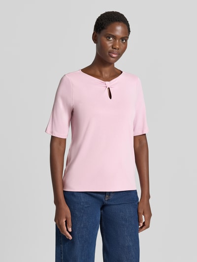 Kobiece modelka nosi Damski t-shirt z mieszanki modalu 'T-Shirt aus Modal-Mix' od MORE, różowy, taliowany krój, dekolt w serek z wycięciem w kształcie łezki, fason z rękawem o dł. 1/2, długość tyłu w rozmiarze 36: 59 cm, widok całej sylwetki z przodu.