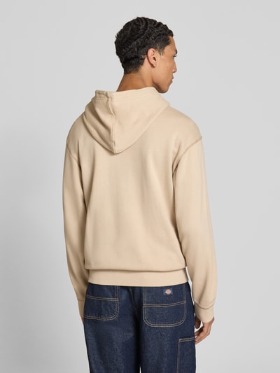 Männermodel trägt Regular Fit Hoodie aus reiner Baumwolle von G-Star RAW in Beige, strukturierte Oberfläche, Ganzkörperansicht Rückansicht.