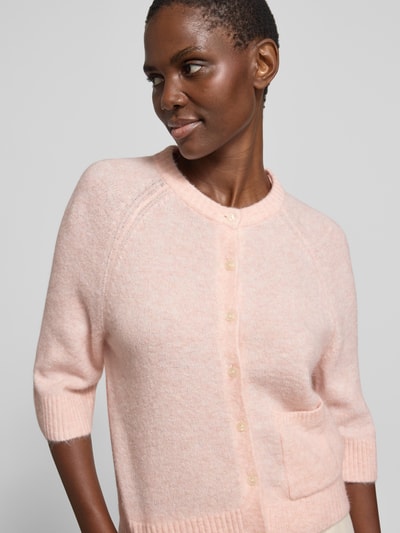 Frauenmodel trägt Cardigan mit Eingrifftasche Modell 'Dathena' von OPUS in zartem Rosa, weiche Mohair-Struktur, Nahaufnahme Oberkörper.