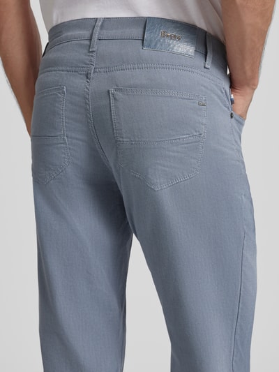 Mężczyznamodel nosi Slim Fit Spodnie materiałowe z 5 kieszeniami Model 'Cadiz' od Brax, mieszanka bawełny z dodatkiem streczu, zapięcie na guzik i zamek błyskawiczny, kolor jasnoszary, długość wewnętrzna nogawki 82 cm, szerokość w pasie 42 cm, widok z tyłu.
