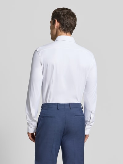 Männermodel trägt Slim Fit Businesshemd aus reiner Baumwolle Modell 'KENNO' von HUGO in Weiß, glatte Struktur, Ganzkörperansicht Rückansicht.