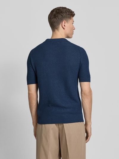 Männermodel trägt Slim Fit Poloshirt mit V-Ausschnitt von GRAN SASSO aus Flachs-Baumwoll-Mix in Dunkelblau, Ganzkörperansicht Rückansicht.