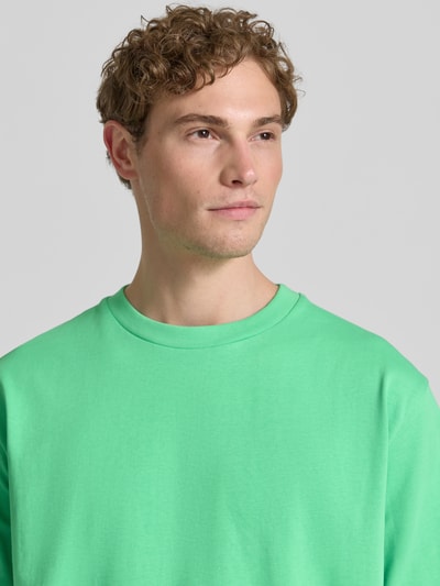 Männermodel trägt Oversized T-Shirt mit Rundhalsausschnitt von Lindbergh aus Reine Baumwolle, leuchtendes Grün, Nahaufnahme Oberkörper. Rückenlänge bei Größe M: 69 cm.