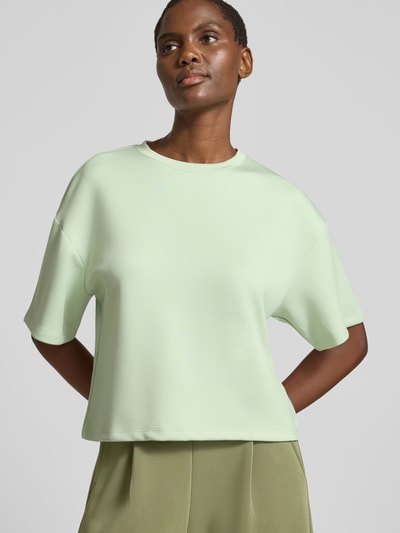 Vrouwenmodel draagt Boxy Fit Sweatshirt uit viscosemix met 1/2-mouwen van MSCH Copenhagen, model 'Nilda Ima', ronde hals, met stretch, lichtgroen, boxy fit, gladde textuur, dames sweatshirt, volledige lichaamsweergave van voren.
