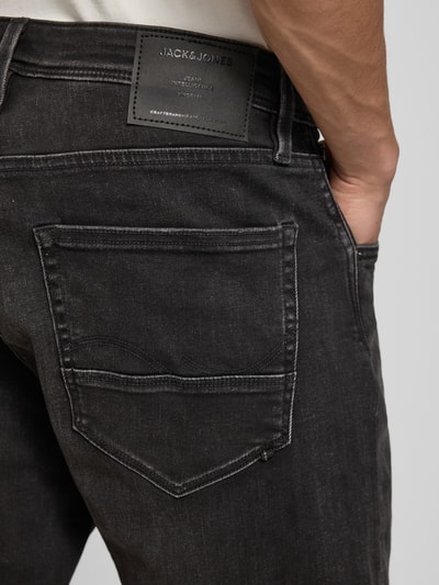 Männermodel trägt Jeansshorts mit Umschlag Modell 'RICK' von Jack & Jones aus schwarzem Baumwoll-Mix mit Stretch-Anteil, Detailaufnahme Rückansicht.