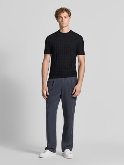Männermodel trägt Strickshirt aus Viskose-Mix mit Strukturmuster von Armani Exchange in Schwarz, Slim Fit, Rundhalsausschnitt, Ganzkörperansicht von vorne.