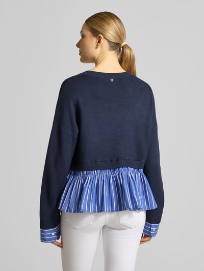 Frauenmodel trägt Strickpullover aus Viskose-Mix im 2-in-1-Look von Liu Jo White, Relaxed-Fit, Rundhalsausschnitt, Rückenlänge 55 cm, Ärmellänge 50 cm, Damen, dunkelblau mit blauer Plissee-Struktur und weißen Streifen, Ganzkörperansicht Rückansicht.
