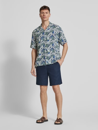 Männermodel trägt Regular Fit Freizeithemd aus reiner Viskose Modell 'Resort' von MCNEAL mit floralem Print, Reverskragen, Kurzarm, Ganzkörperansicht von vorne.