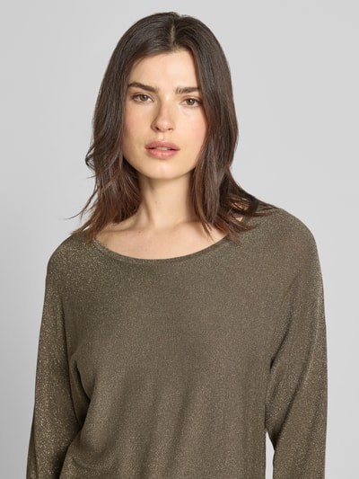 Modelka kobieca nosi Strickshirt aus Viskose-Mix mit 3/4-Arm od comma, mieszanka wiskozy, krój regular fit, efekt błyszczący, okrągły dekolt, rękaw o dł. 3/4, długość tyłu w rozmiarze 36: 61 cm, długość rękawów w rozmiarze 36: 50 cm, oliwkowy kolor, błyszcząca tekstura, widok na górną część sylwetki, z przodu